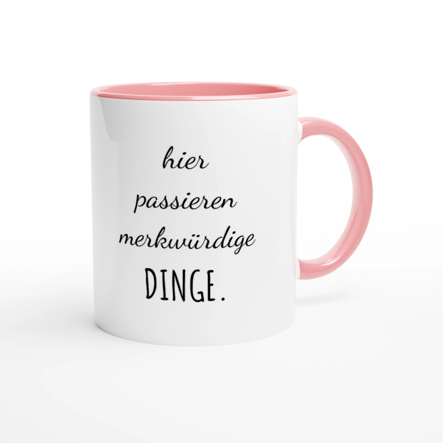 Zweifarbige Keramiktasse 325 ml mit Aufdruck "Hier passieren merkwürdige Dinge" in Rosa – Schreibtischtasse von Vollzeitfrust
