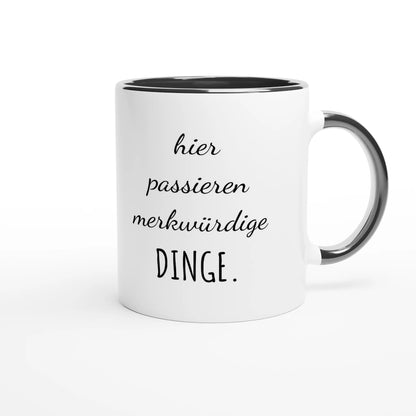 Zweifarbige Keramiktasse 325 ml mit Aufdruck "Hier passieren merkwürdige Dinge" in Schwarz – Schreibtischtasse von Vollzeitfrust
